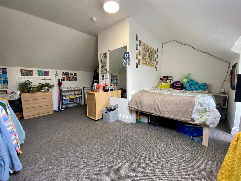 Bright, spacious bedroom with bed and study are...