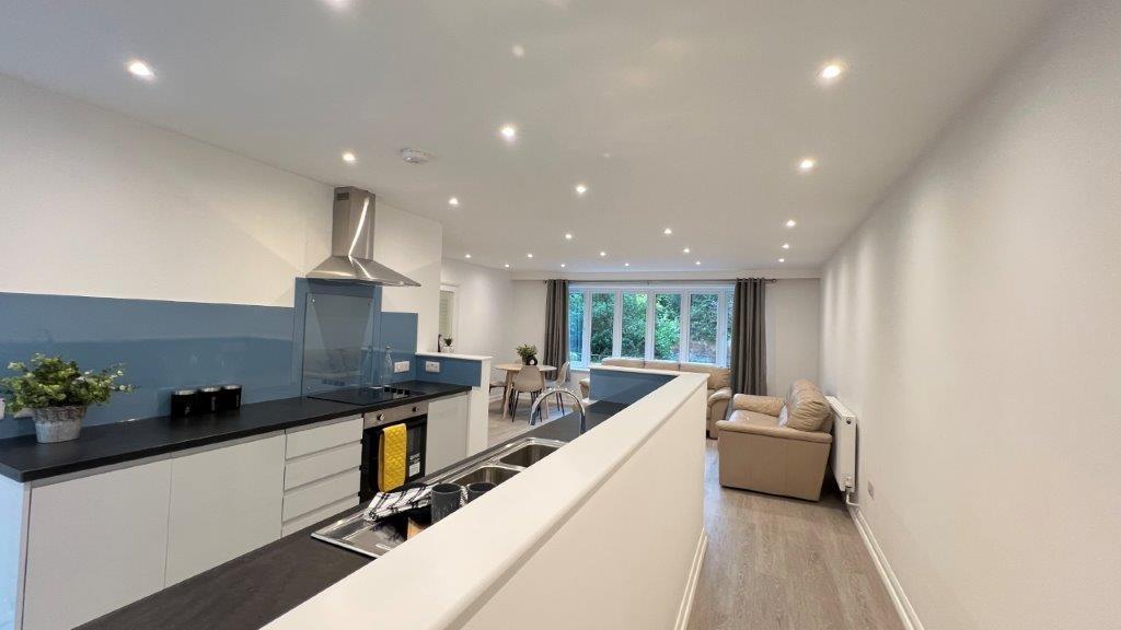 Modern open-plan lounge with kitchen and garden...