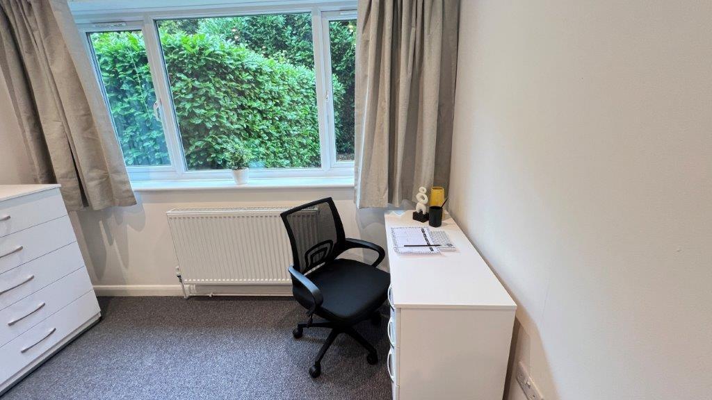 Bright single bedroom with desk and leafy view...