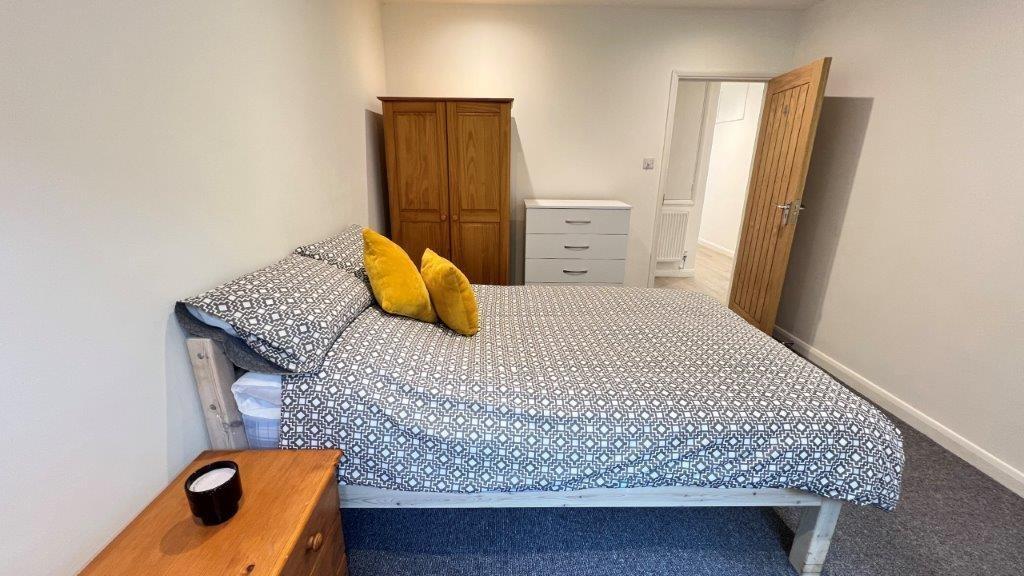 Neat double bedroom with cosy bedding and stora...