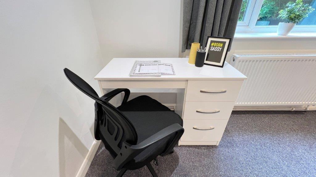 Bright bedroom workspace with desk and window...
