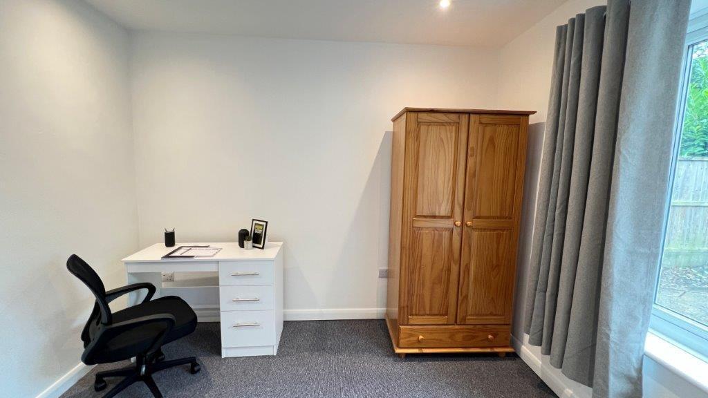 Bright bedroom with desk, wardrobe and largewin...