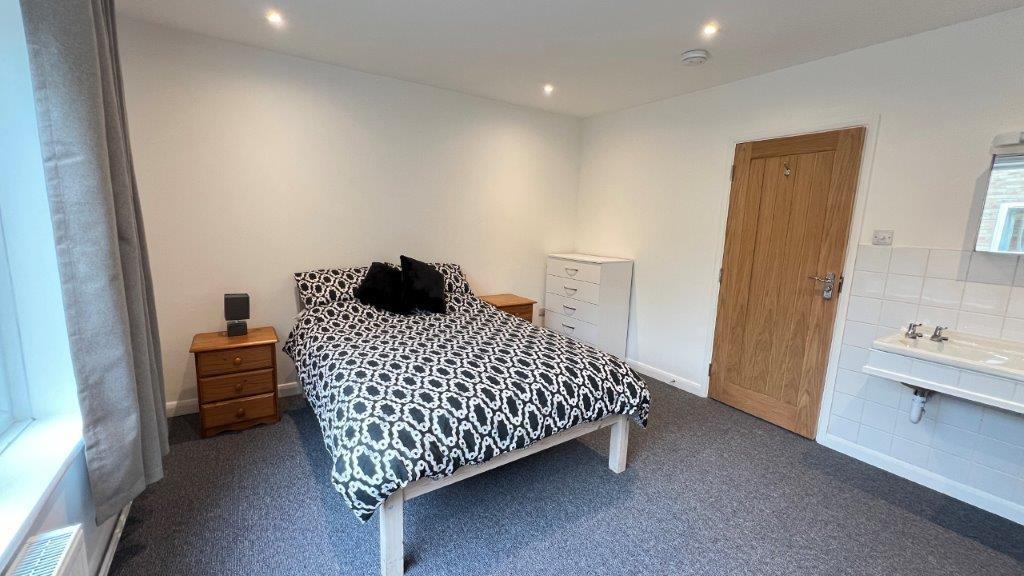 Bright double bedroom with patterned bed and de...