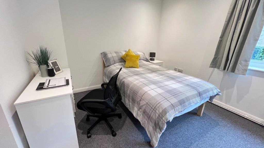 Bright, tidy bedroom with bed and desk...