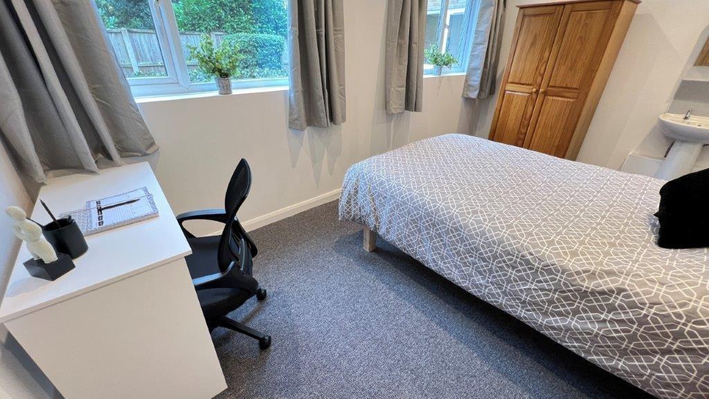 Bright, tidy single bedroom with desk and stora...