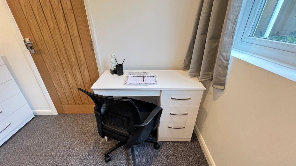 Bright study area with desk and chair by window...