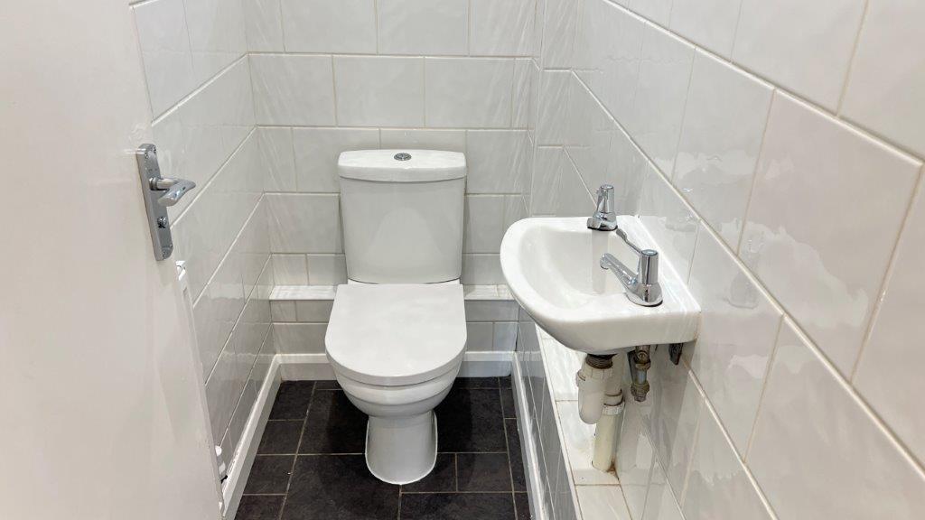 Compact clean bathroom with white tiles...