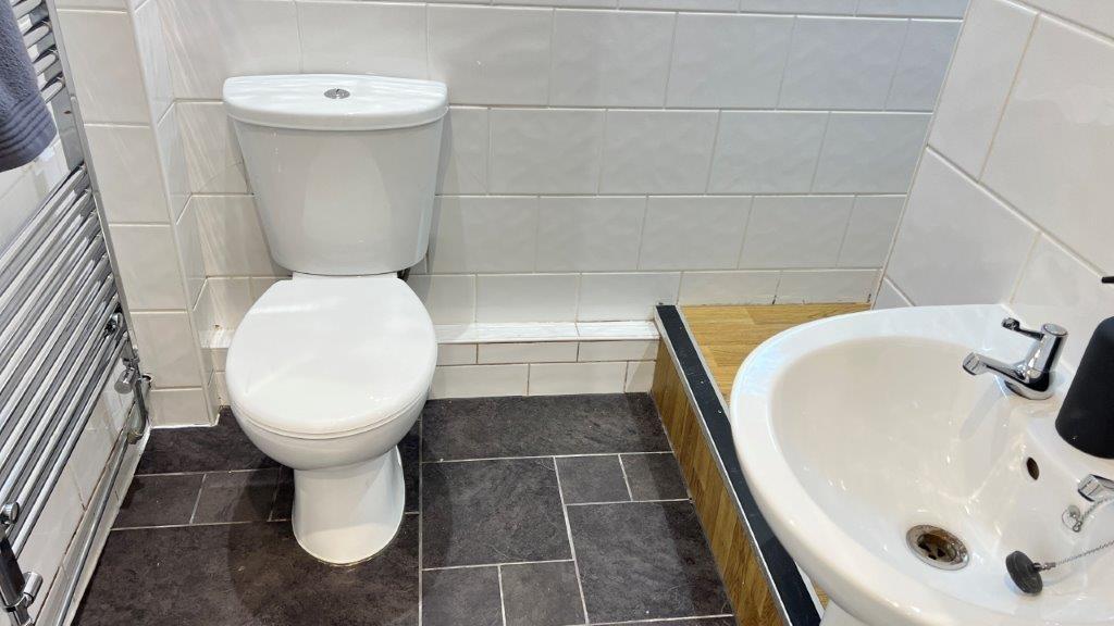 Compact bathroom with modern sink and heated to...