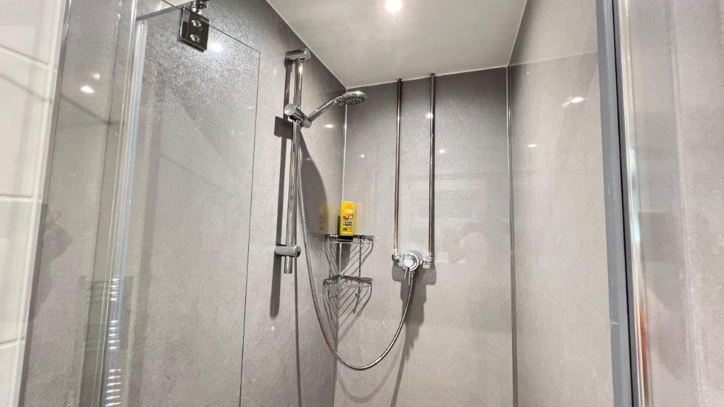 Modern tiled shower with glass enclosure...