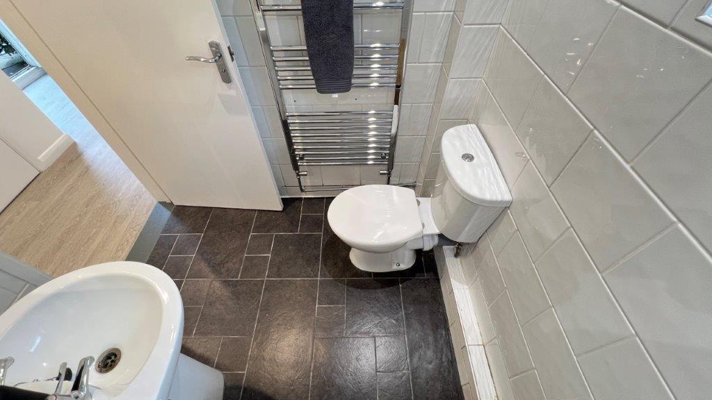 Neat modern bathroom with tiled walls and heate...
