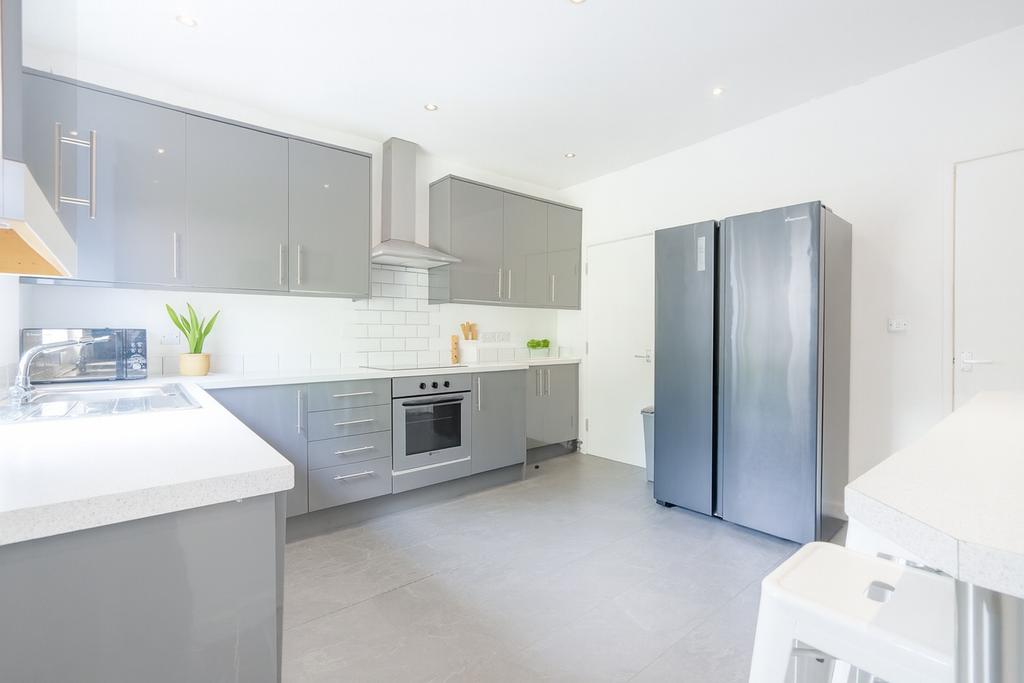 Bright modern kitchen with sleek grey cabinets,...