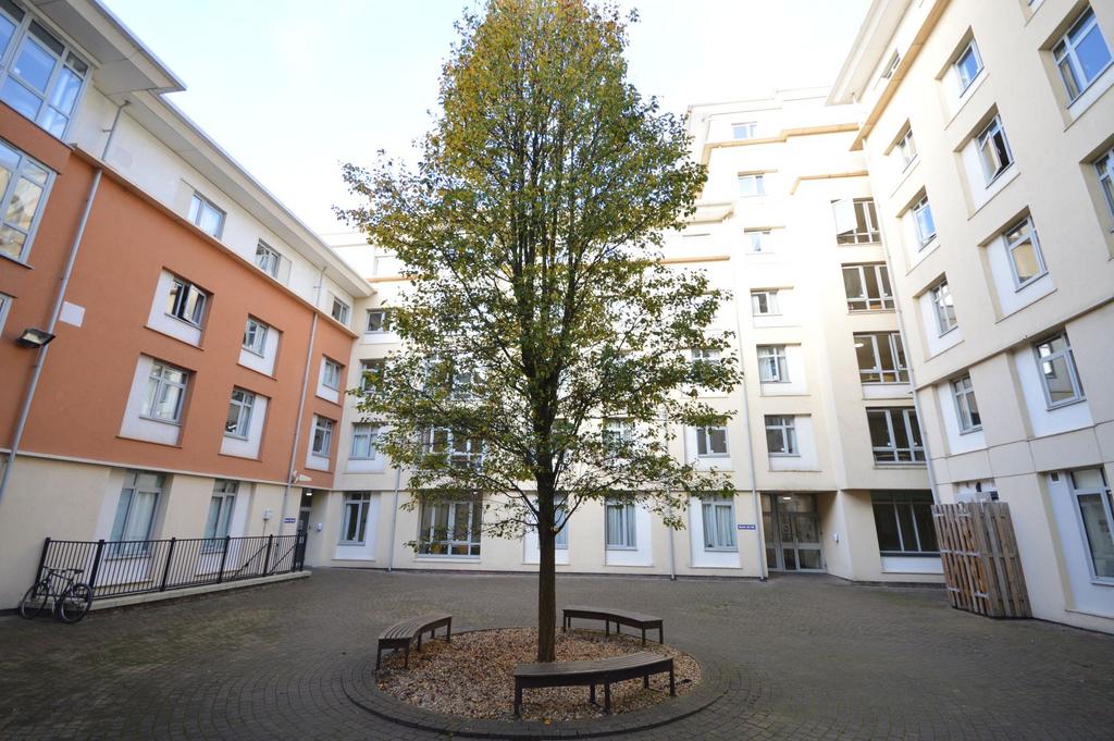 Sunny central courtyard with seating and mature...