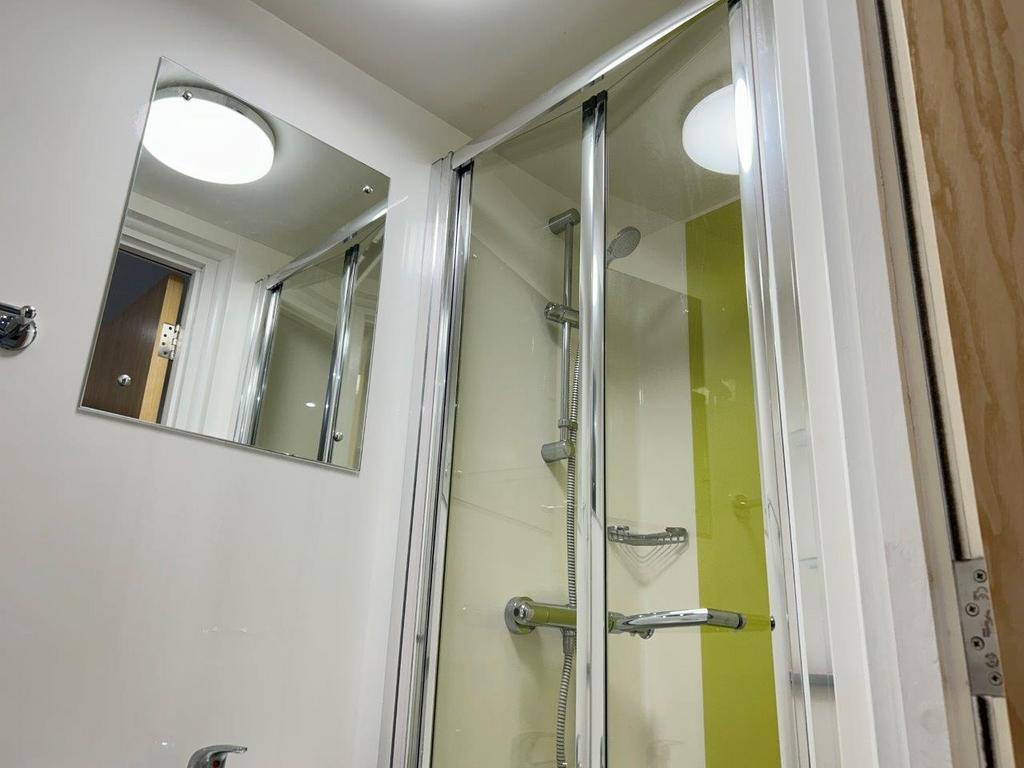 Bright modern bathroom with glass shower cubicl...