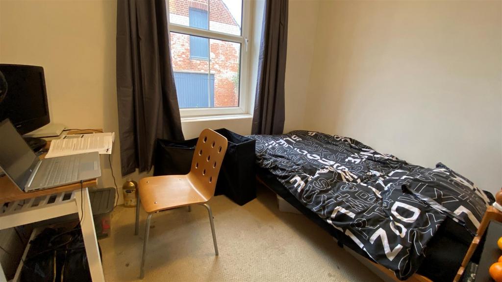 Bright bedroom with desk and comfortable bed...