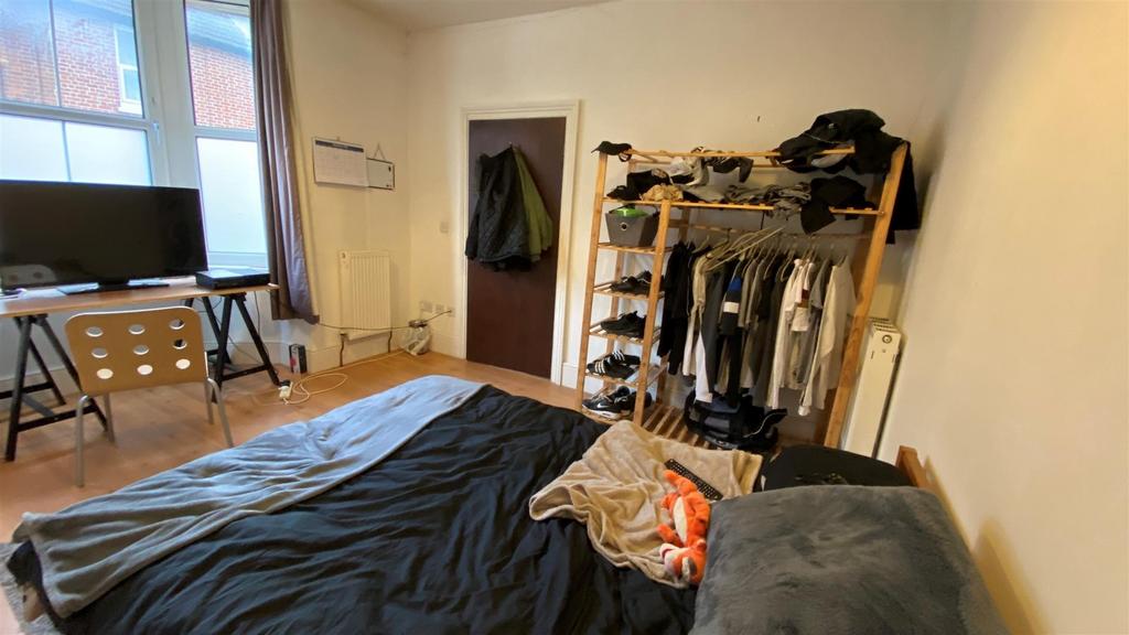 Bright bedroom with large window and desk area...