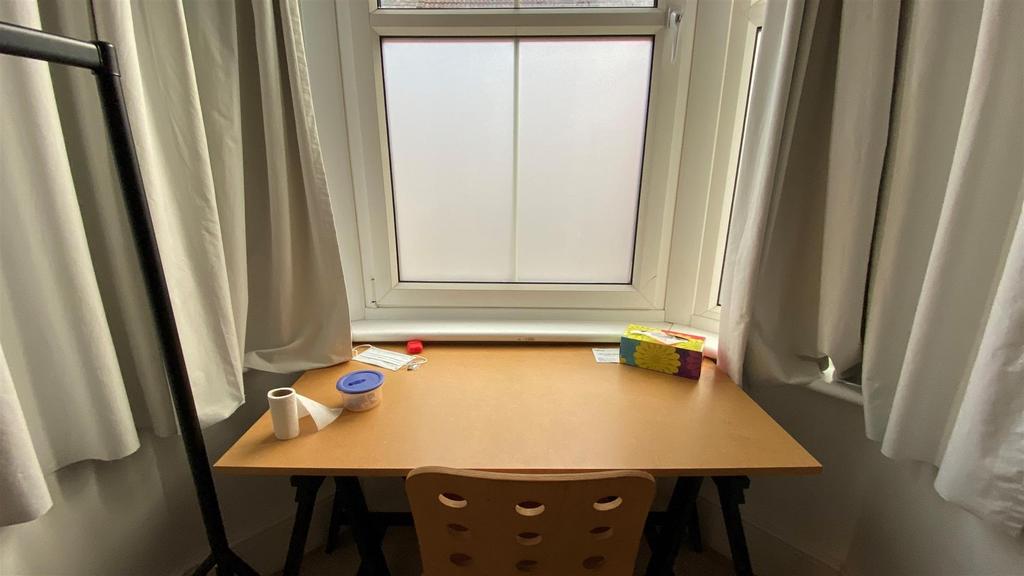 Desk by a bright window with curtains and tidy ...