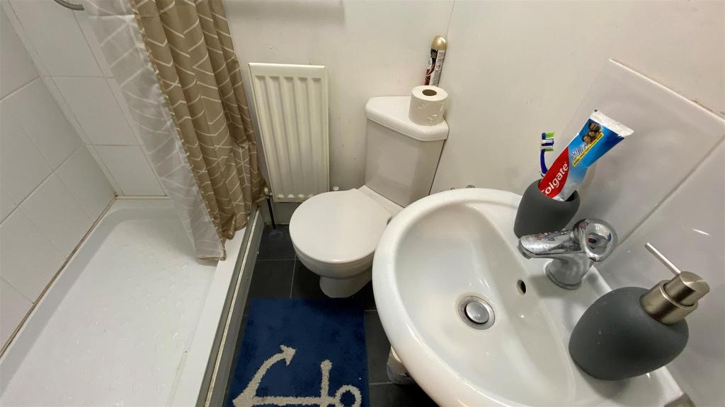 Compact bathroom with shower, sink and tidy lay...