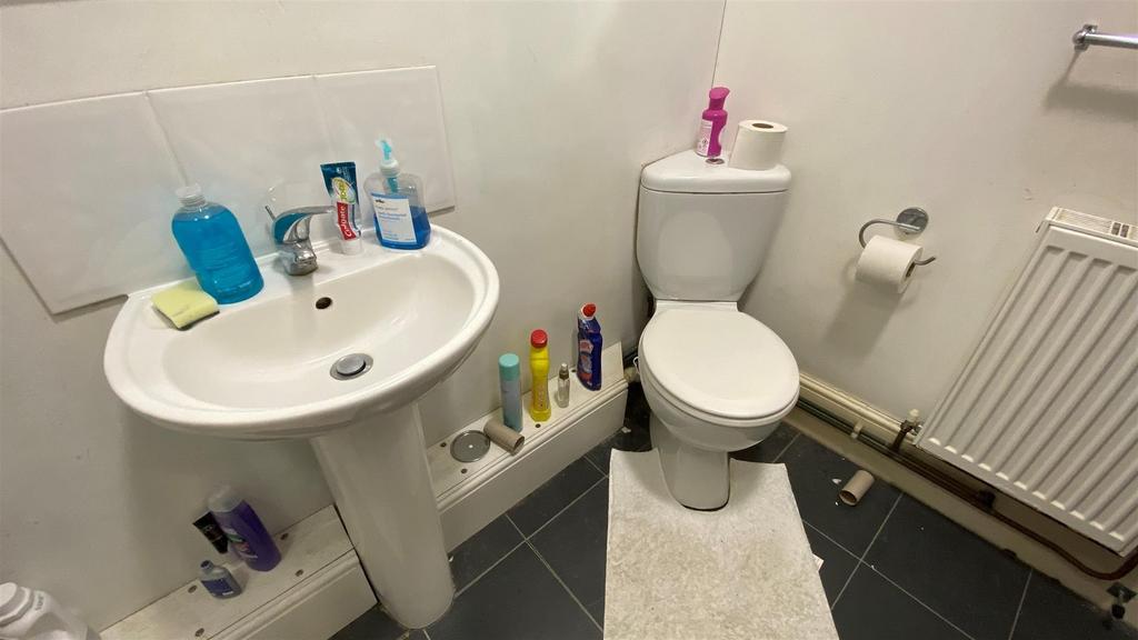 Clean white bathroom with pedestal sink and toi...