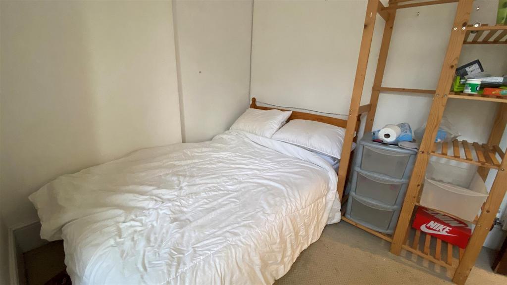 Cozy single bedroom with neat shelving and bed...
