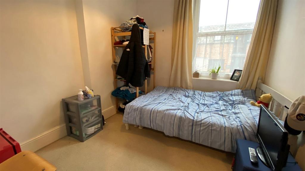 Bright single bedroom with window and simple de...
