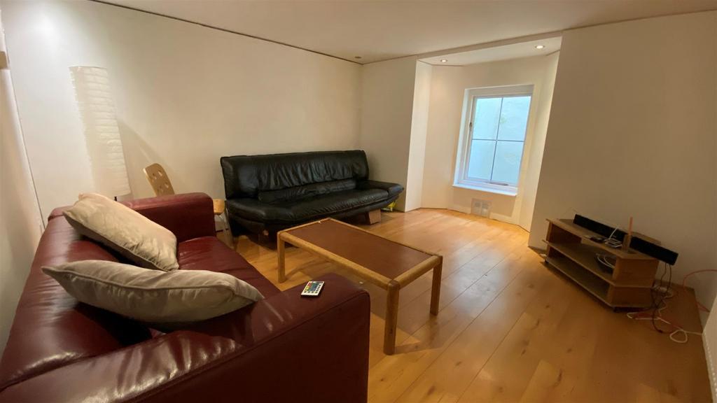 Spacious living room with wood floors and seati...