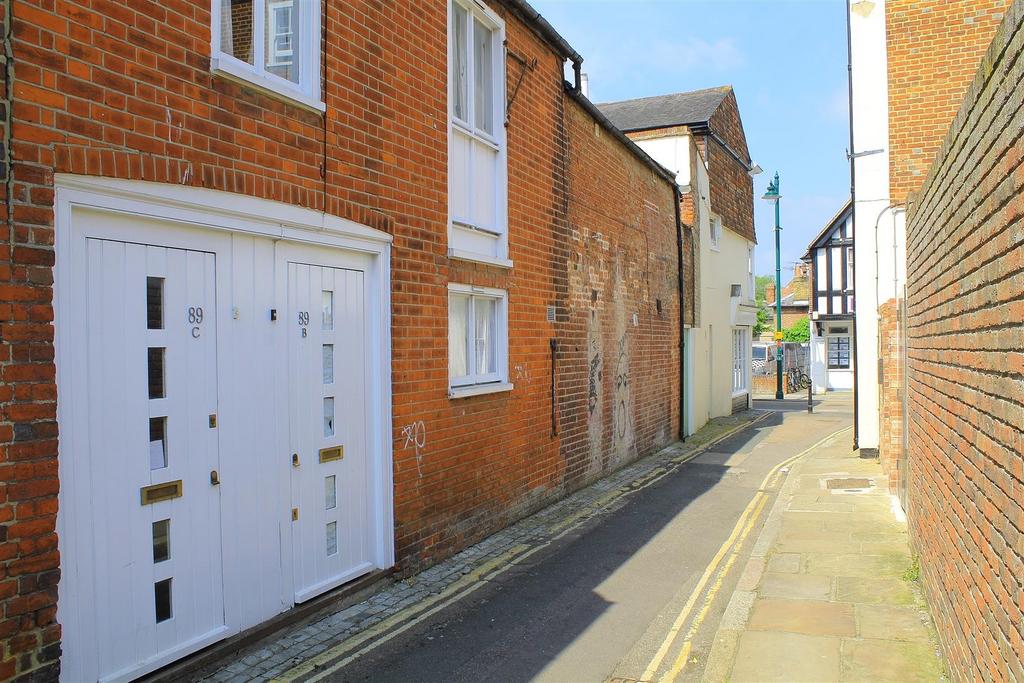 Quiet narrow street with brick-fronted property...