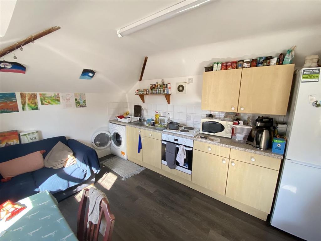 Bright fitted kitchen with seating and applianc...