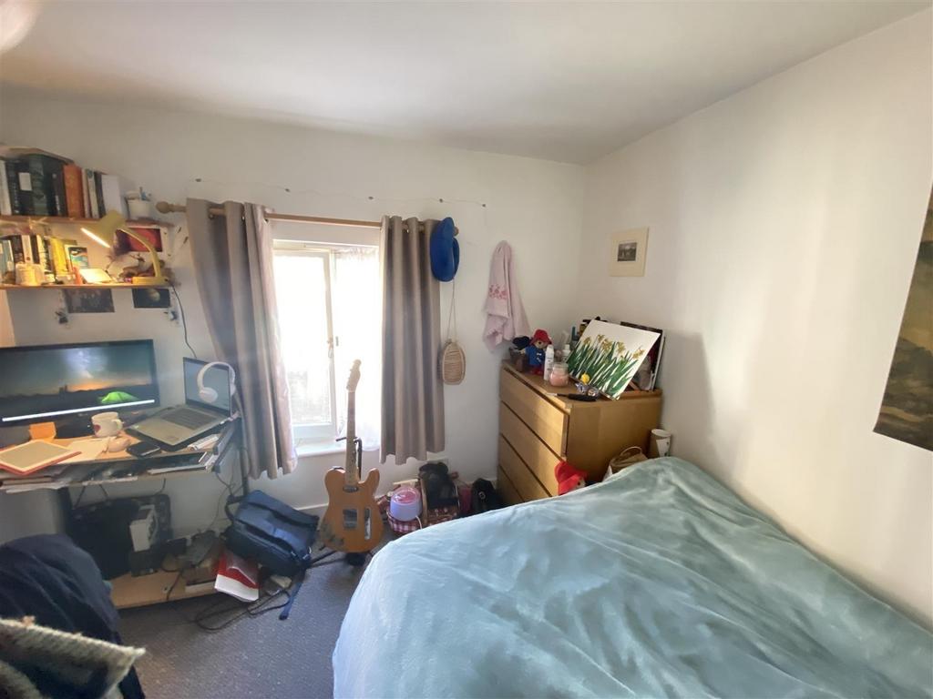 Bright bedroom with desk and storage...