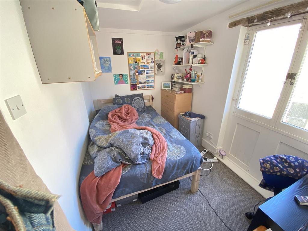 Bright bedroom with shelving and outdoor door...