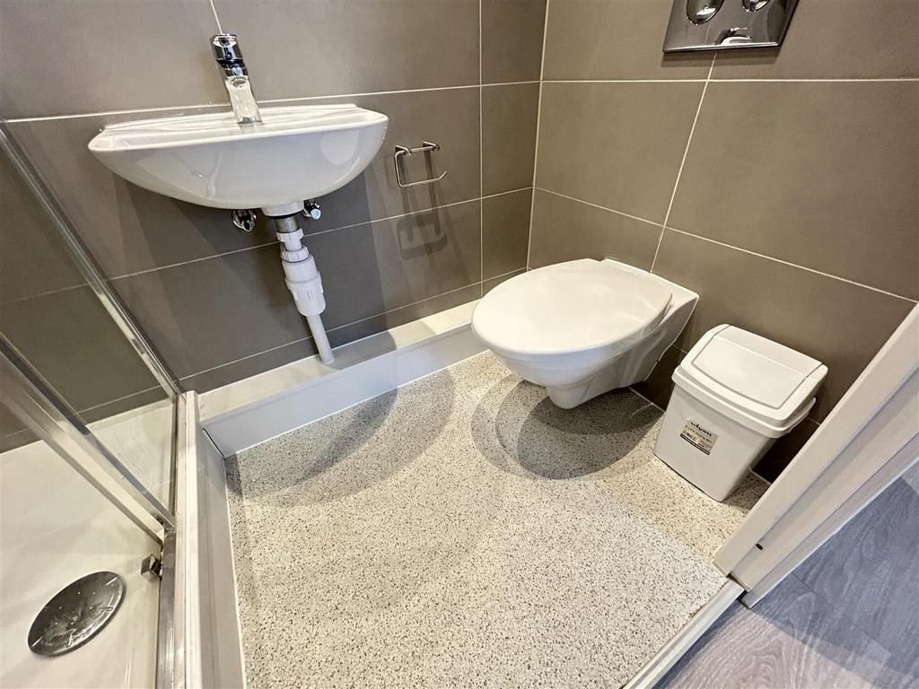Modern tiled bathroom with shower and wall-moun...