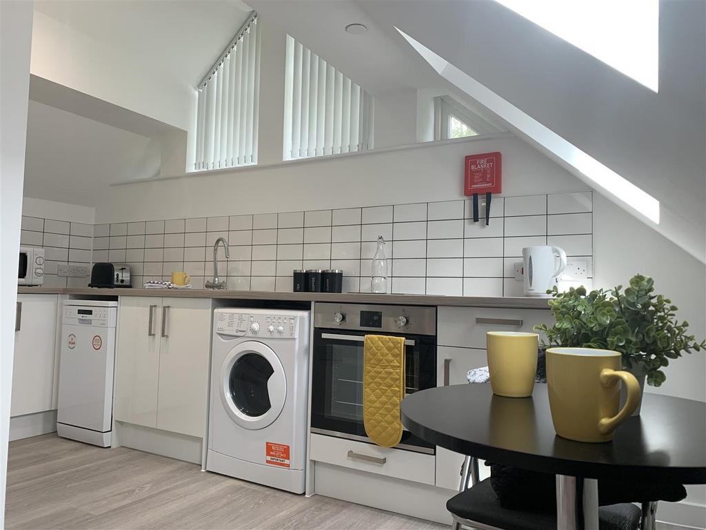 Bright modern kitchen with appliances and dinin...
