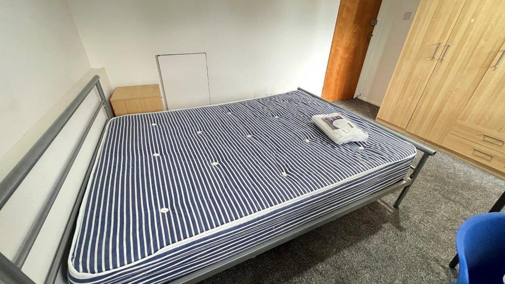 Simple double bedroom with wardrobe and metal b...