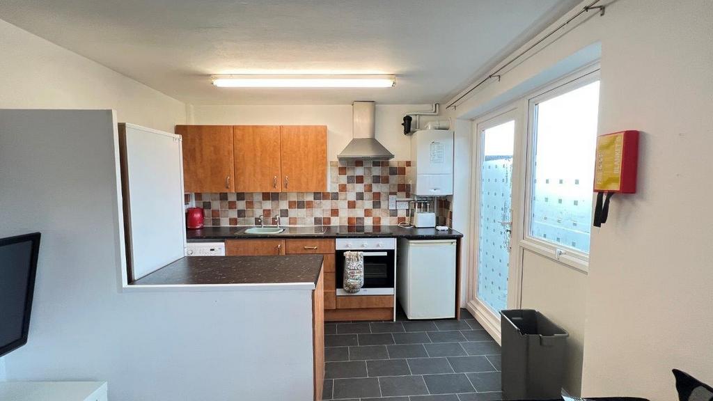 Bright kitchen with fitted units and tiled spla...