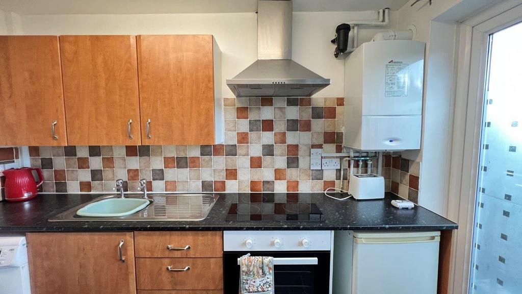 Compact kitchen with tiled splashback and fitte...