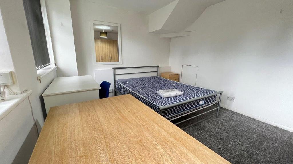 Bright furnished bedroom with desk and double b...