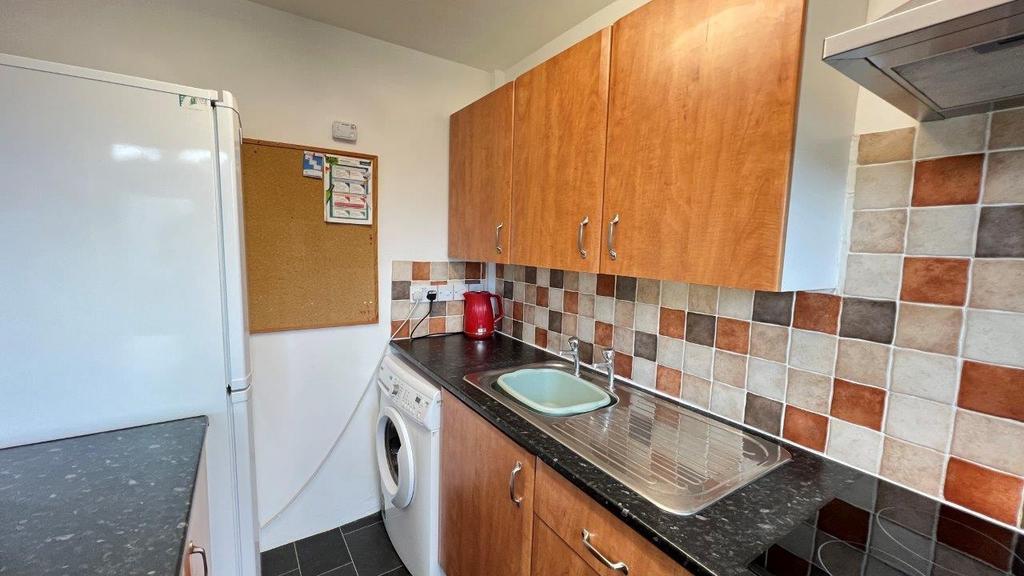 Bright fitted kitchen with tiled splashback...