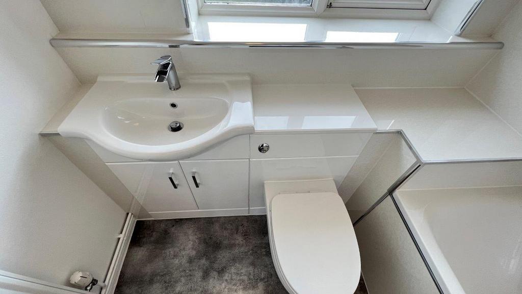Bright, modern bathroom with white fixtures...