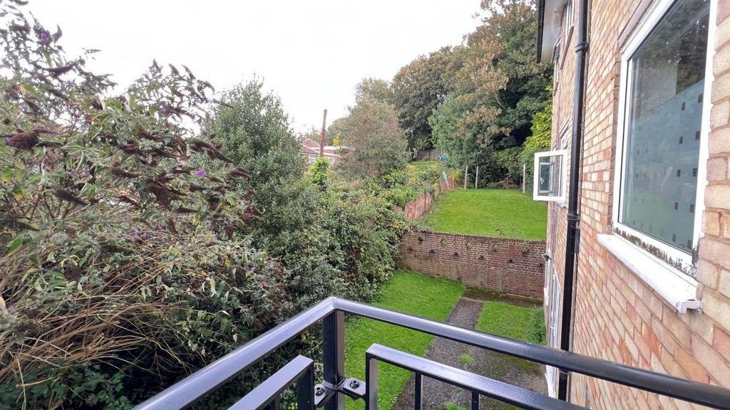 Balcony view overlooking a green communal garde...