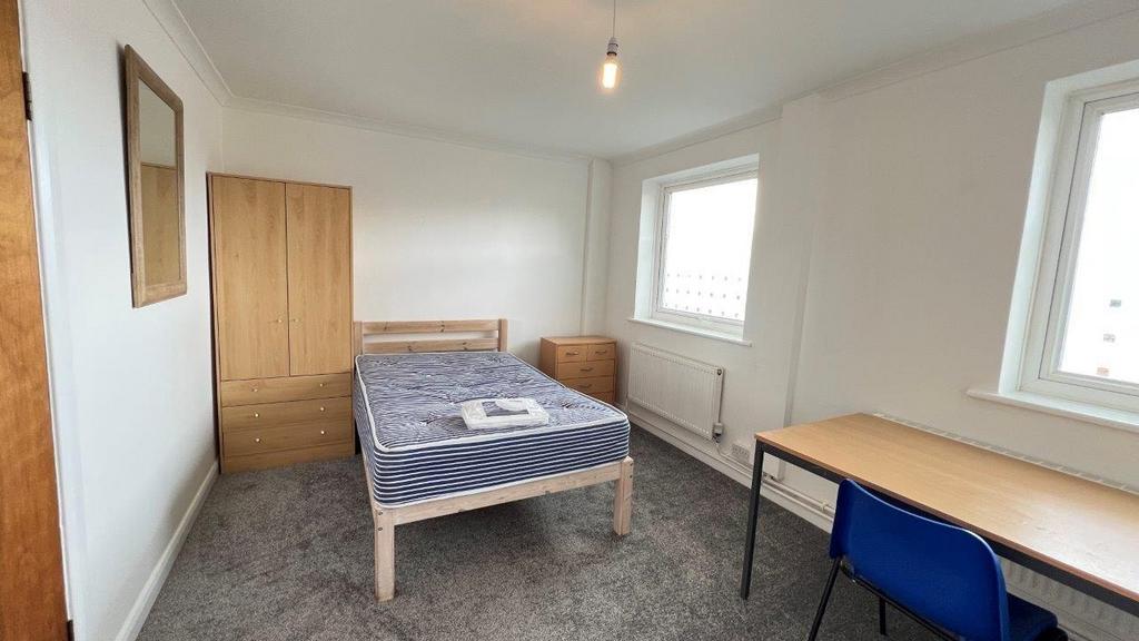 Bright furnished bedroom with desk and wardrobe...