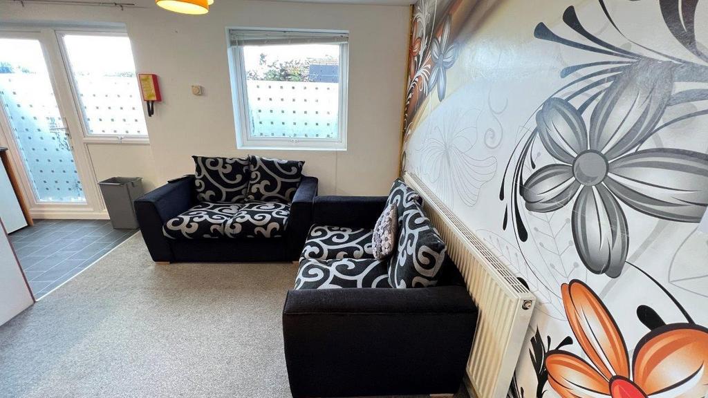 Bright lounge with patterned sofas and featurew...