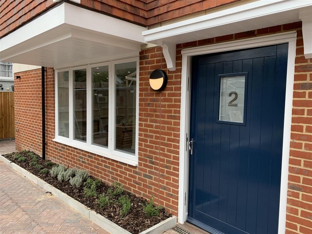 Neat modern entrance with planted border...