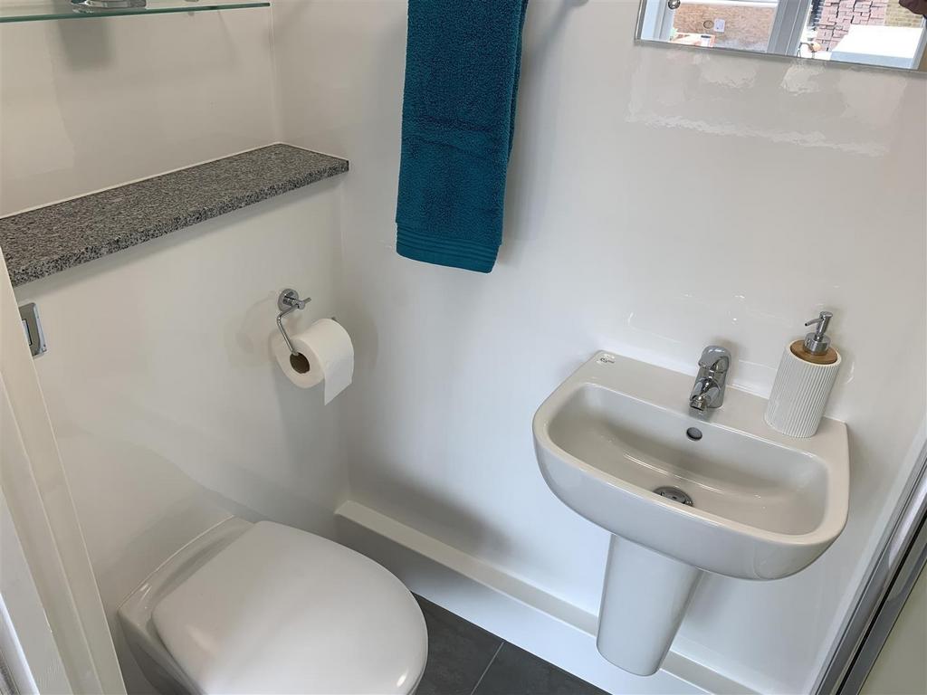 Compact modern WC with basin and shelving...
