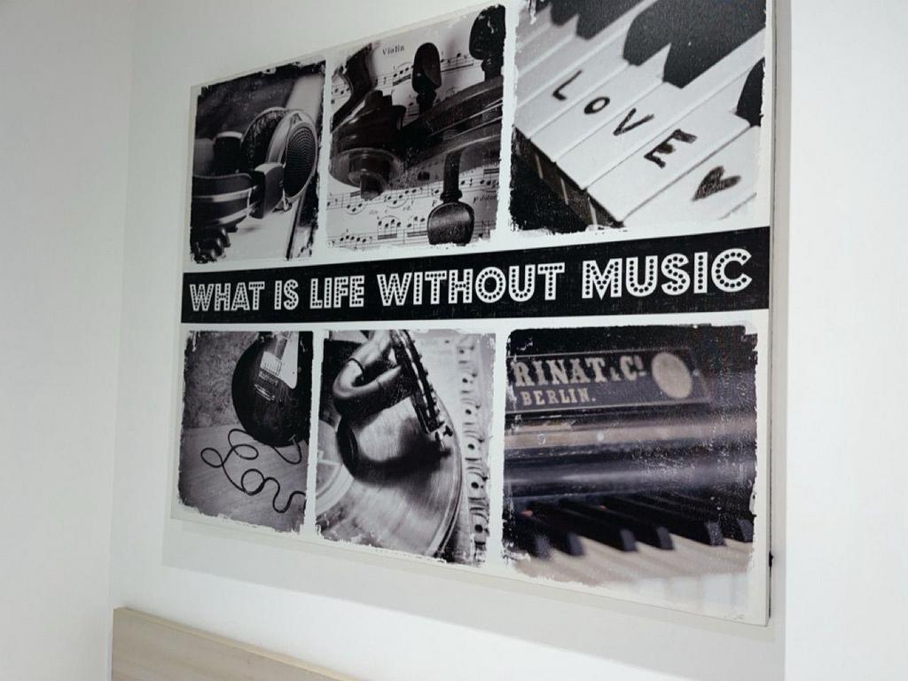 Monochrome music-themed wall art above bed...