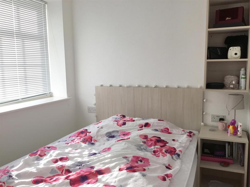 Bright bedroom with large window and built-in s...