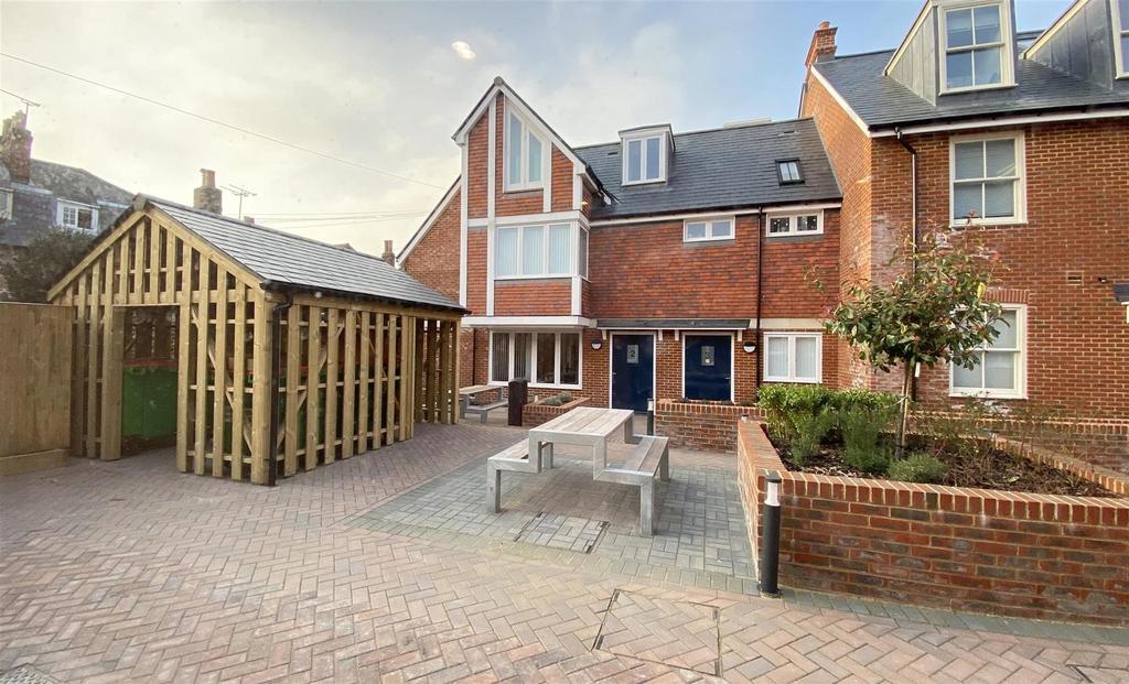 Shared paved courtyard with seating and covered...