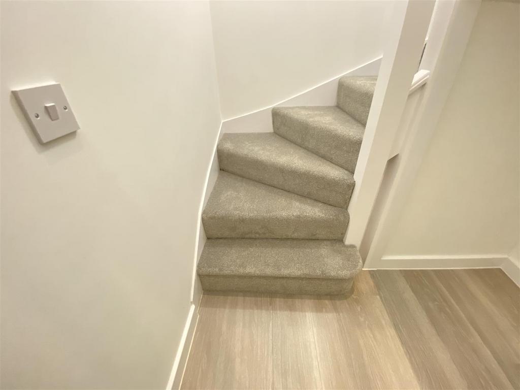 Clean carpeted staircase with modern flooring...