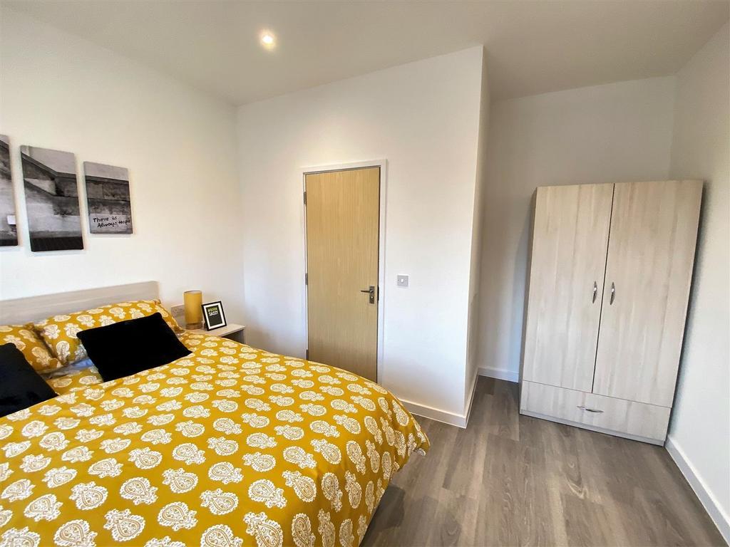 Bright bedroom with patterned duvet and wardrob...