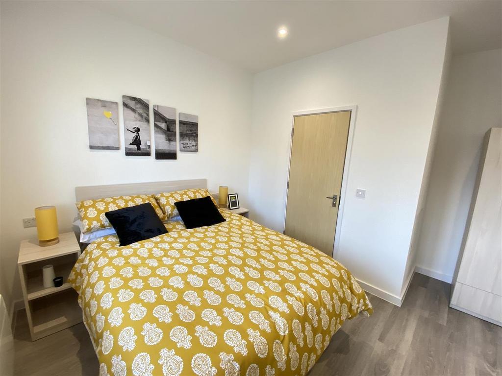 Bright, modern double bedroom with patterned be...