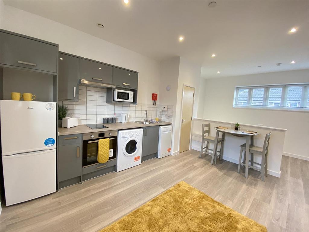Modern fitted kitchen with breakfast bar and wo...