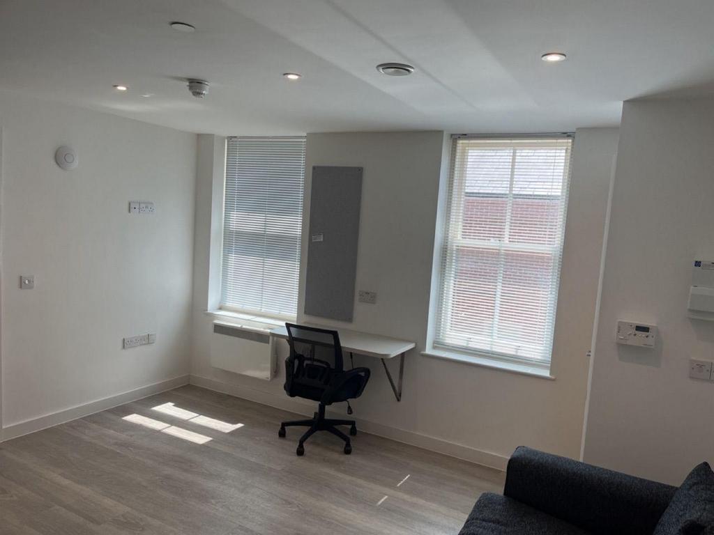 Bright furnished room with study desk and seati...